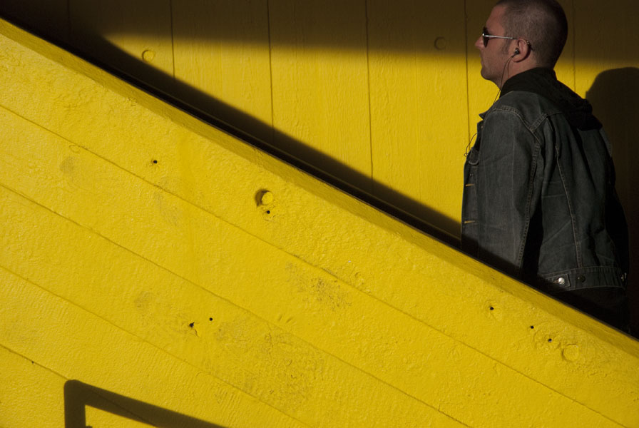 Man climbing steps, yellow background