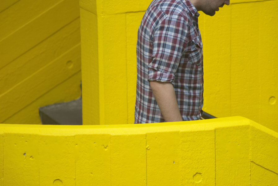 Man descending steps, yellow background